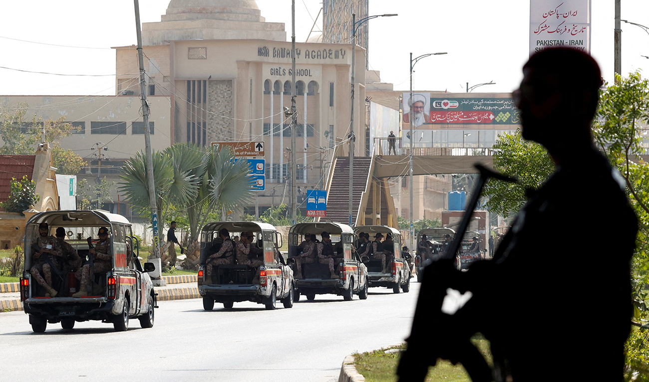 A police officer is silhouetted as he stands guard while paramilitary forces patrol as a security measure, following the visit of the Iranian President Ebrahim Raisi, in Karachi, Pakistan April 23, 2024. (Reuters)