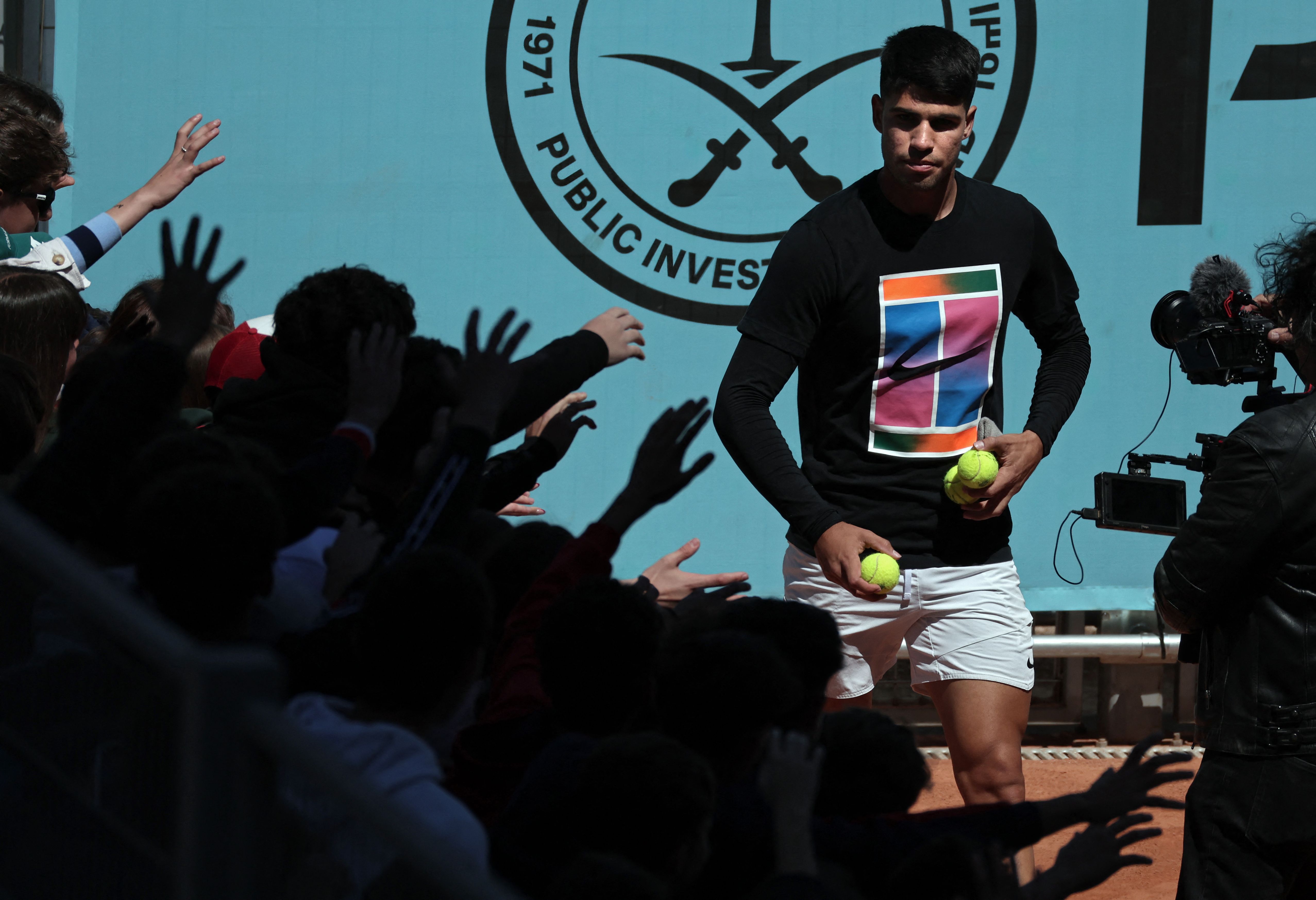 Spain's Carlos Alcaraz offers some balls to supporters during a training ahead of 2024 ATP Tour Madrid Open tennis tournament at Caja Magica in Madrid on April 23, 2024. (AFP)