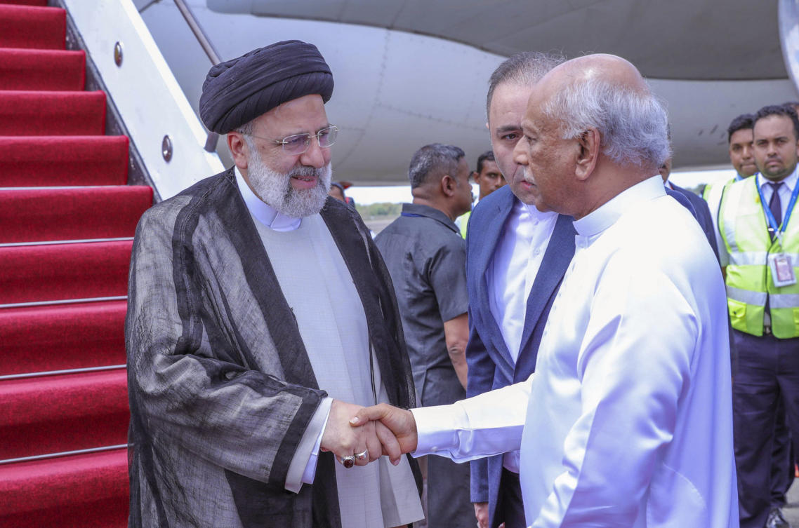 Iranian President Ebrahim Raisi, left is received by Sri Lankan Prime Minister Dinesh Gunawardena as he arrives at the Mattala International airport in Mattala, Sri Lanka. (Sri Lanka President's Office via AP)
