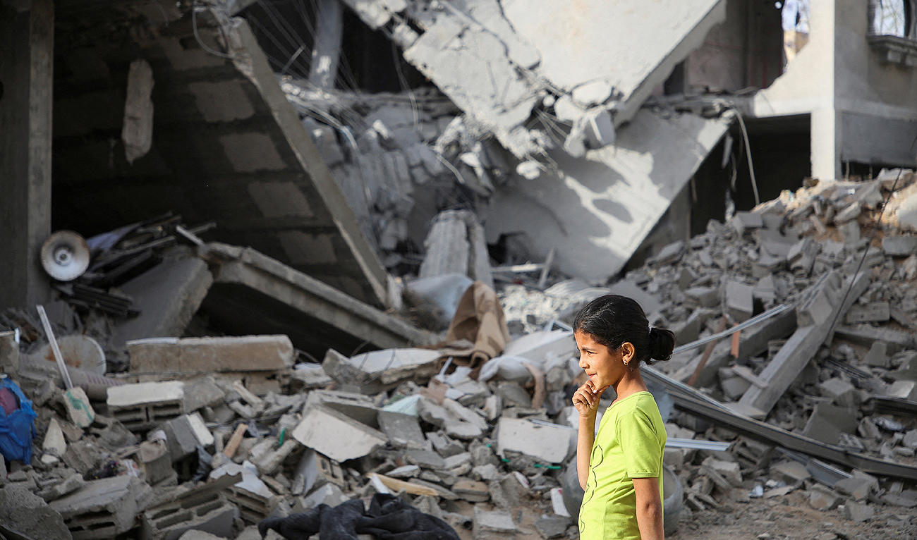 A Palestinian girl walks past the site of an Israeli strike on a house, amid the ongoing conflict between Israel and the Palestinian Islamist group Hamas, in Rafah, in the southern Gaza Strip, April 25, 2024. (REUTERS)