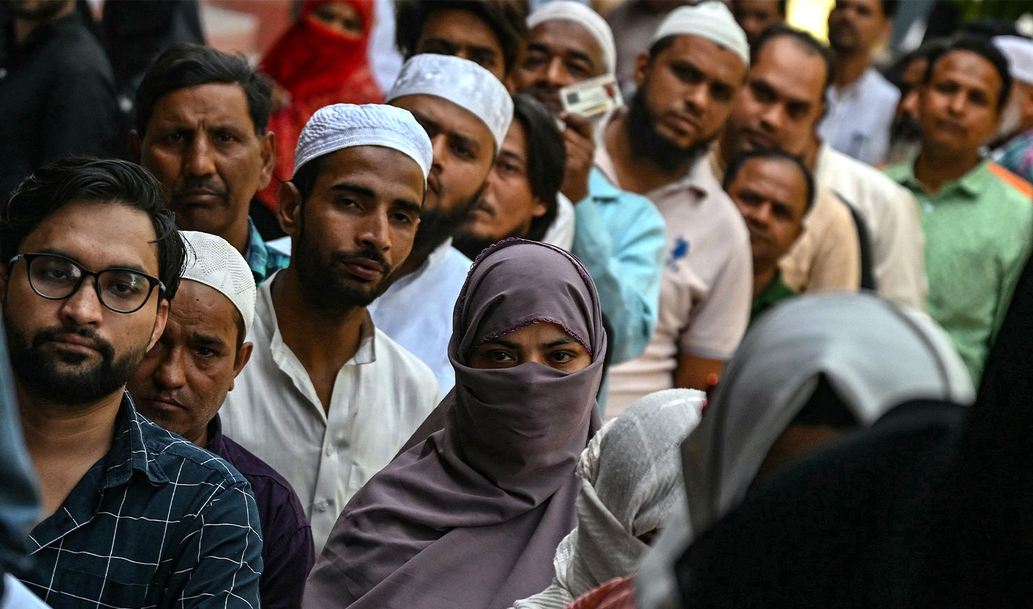 Voters wait outside a polling booth before casting their votes during the second phase of India's general election in Amroha, in country's Uttar Pradesh state on April 26, 2024. (AFP)