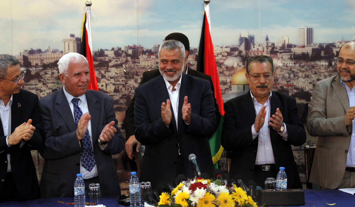 (From L to R) Palestinian legislator Mustafa Barghouti, Palestinian Fatah delegation chief Azzam al-Ahmed, Hamas prime minister in the Gaza Strip Ismail Haniya, secretary-general of the Palestinian Arab Front (PAF) Jameel Shehadeh and Hamas deputy leader Musa Abu Marzuk clap as they celebrate in Gaza City on April 23, 2014 after West Bank and Gaza Strip leaders agreed to form a unity government within five weeks as peace talks with Israel face collapse. (AFP file photo)