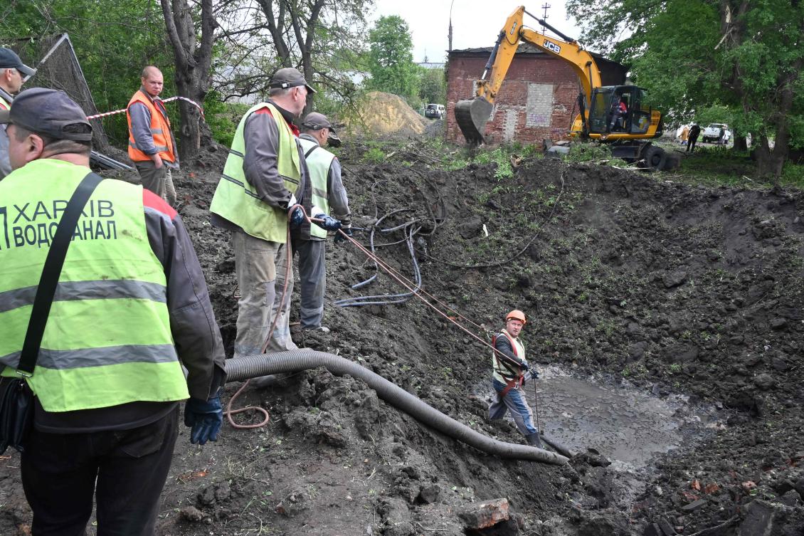 Utility workers operate next to a crater in the courtyard of a hospital in Kharkiv on Apr. 27, 2024, as Russia launched a “massive” missile strike at Ukraine overnight, damaging four power plants in the latest barrage targeting the country’s energy supply. (AFP)