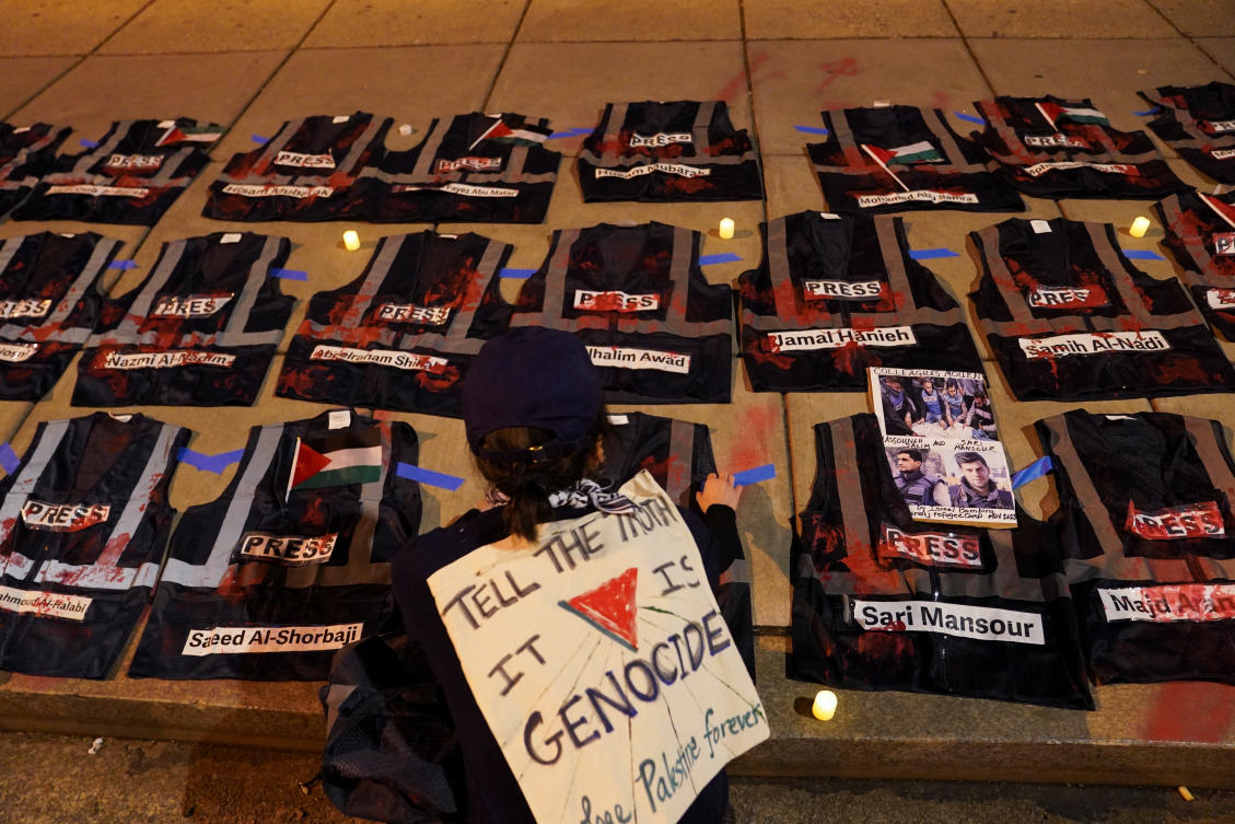 A protester kneels near vests representing bulletproof press vests, symbolic of journalists who were killed while covering Israel' war on Gaza near the annual White House Correspondents Association (WHCA) Dinner in Washington, US, April 27, 2024. (File/Reuters)