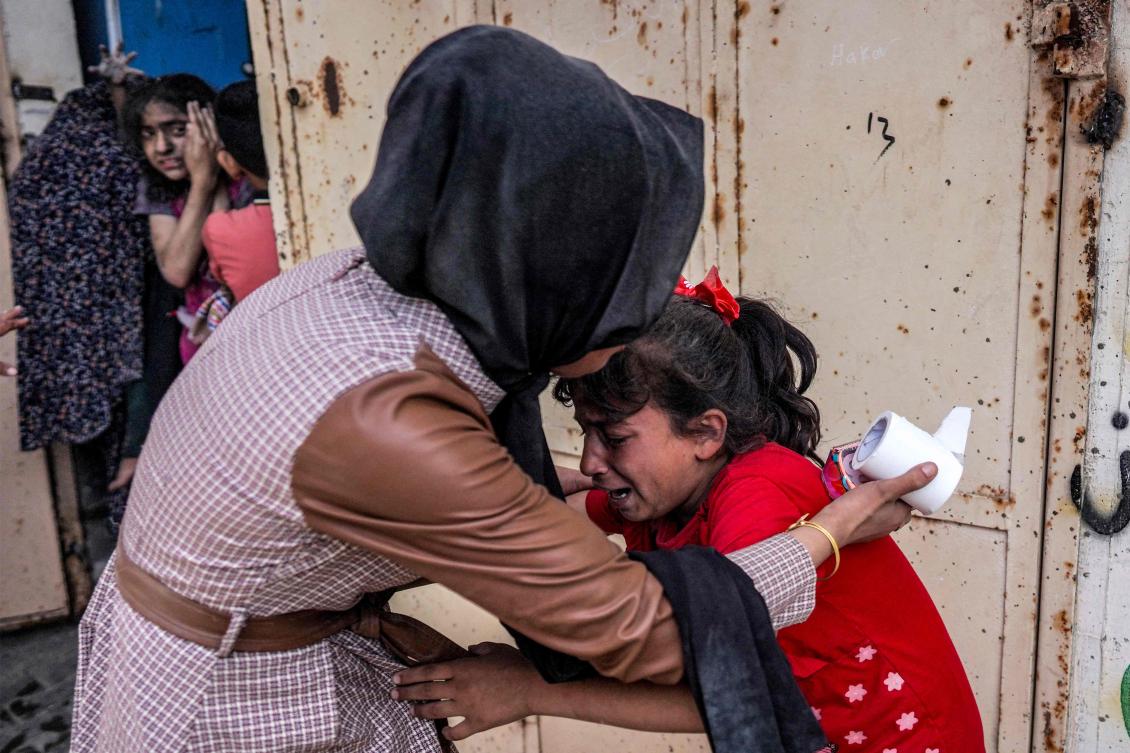 A woman consoles a shocked child reacting after Israeli bombardment in Nuseirat in the central Gaza Strip on April 29, 2024. (AFP)