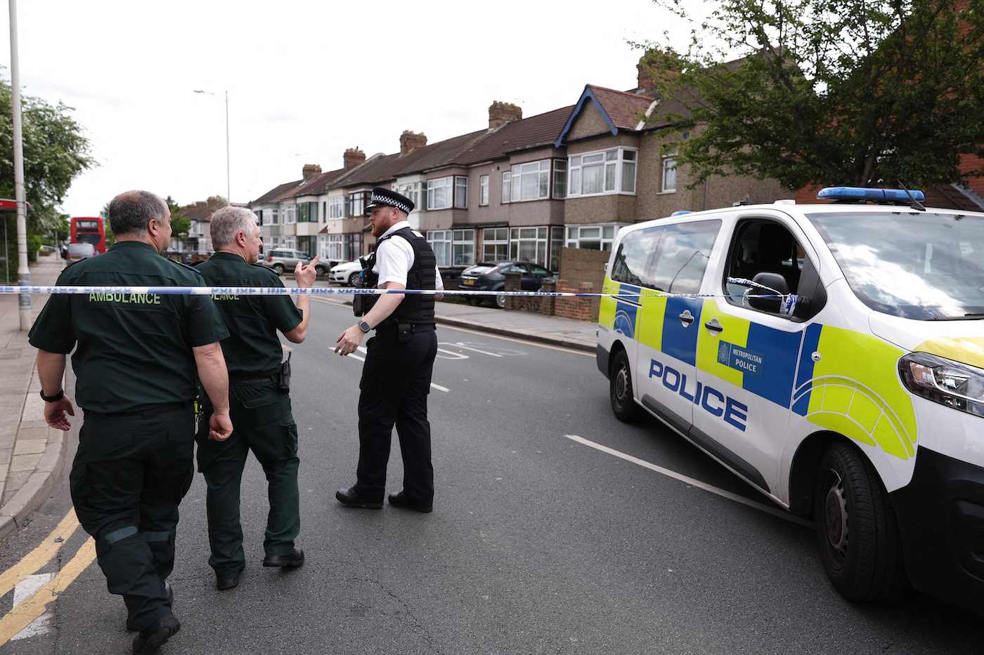 A police officer speaks to ambulance staff at a crime scene in Hainault, east of London on April 30, 2024 where a 36-year-old man wielding a sword was arrested. (AFP)