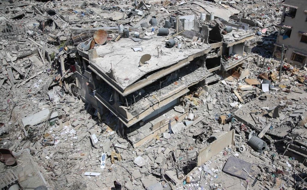 A Palestinian man walks on rubble in a devastated area around Gaza’s Al-Shifa hospital on April 3, 2024, amid the ongoing conflict between Israel and the Palestinian Hamas militant group. (AFP)