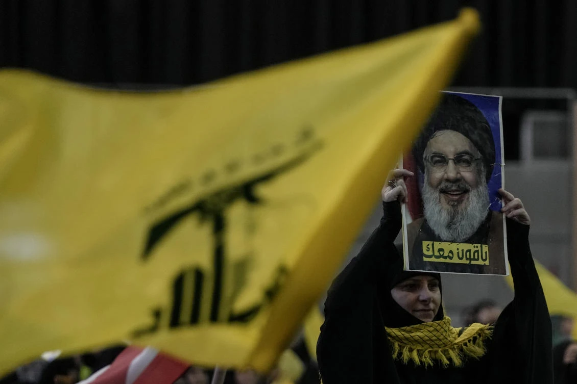 A Supporter of the Iranian-backed Hezbollah group holds up a portrait of Hezbollah leader Sayyed Hassan Nasrallah with Arabic words reading : “We will stay with you,” during a rally to mark Jerusalem day or Al-Quds day, in a southern suburb of Beirut on Apr. 5, 2024. (AP)