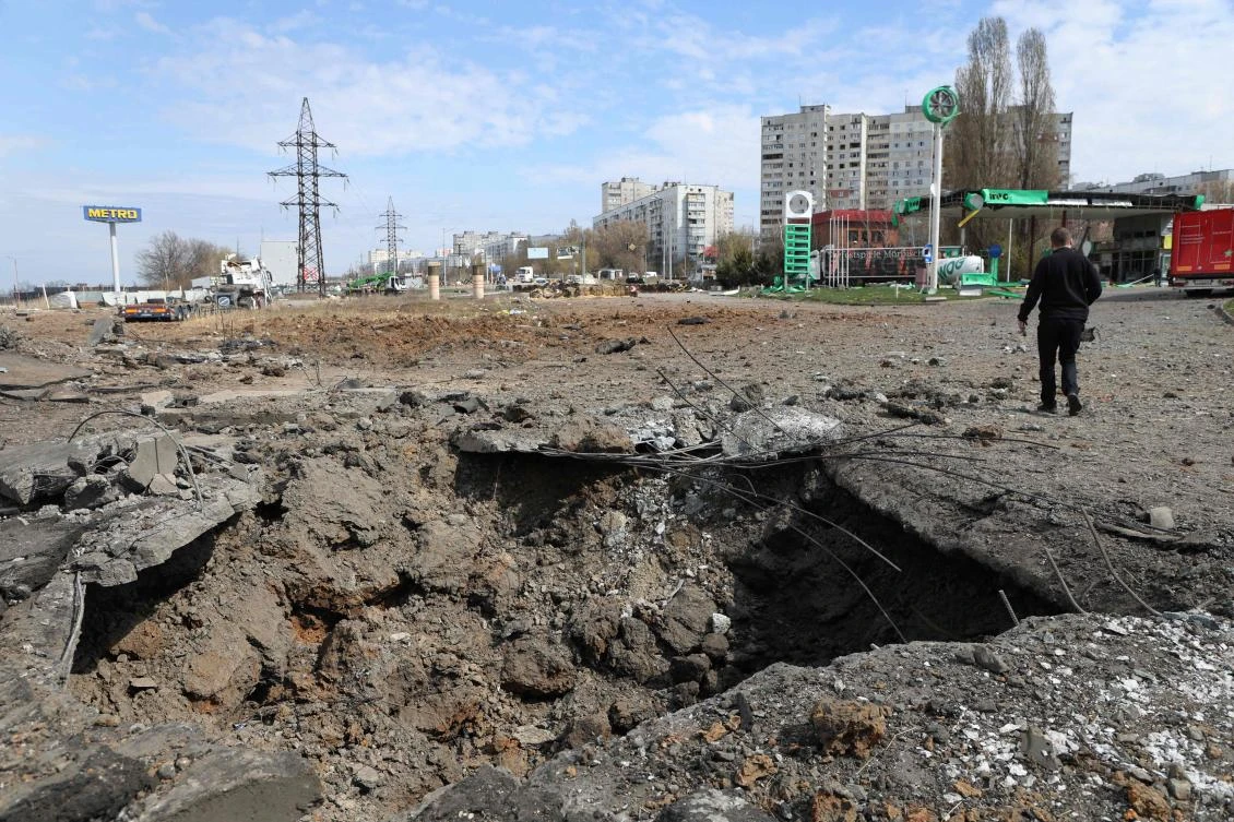 A man walks past a crater after missiles strike in Kharkiv on Apr. 6, 2024, amid Russian invasion in Ukraine. (AFP)