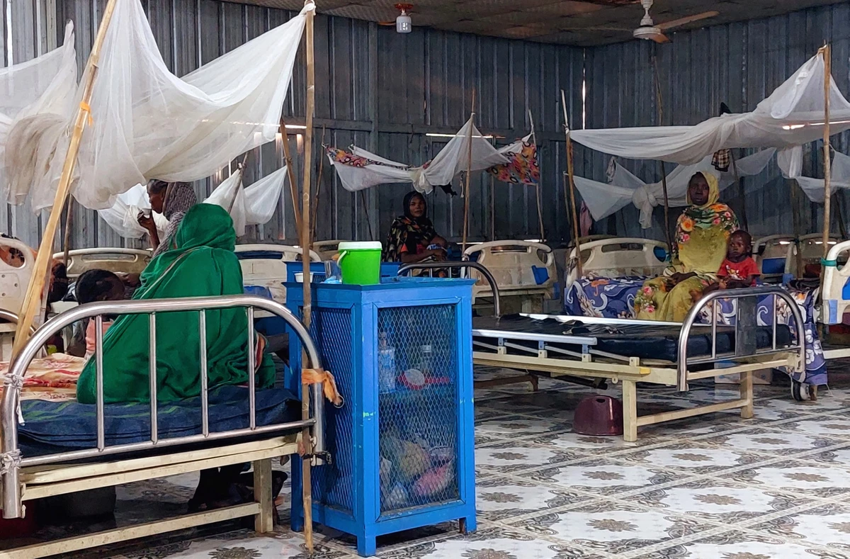 Women and a children sit waiting at a nutrition centre at the Kalma camp for the displaced just outside Nyala, the provincial capital of South Darfur state, on November 20, 2022. (AFP file photo)