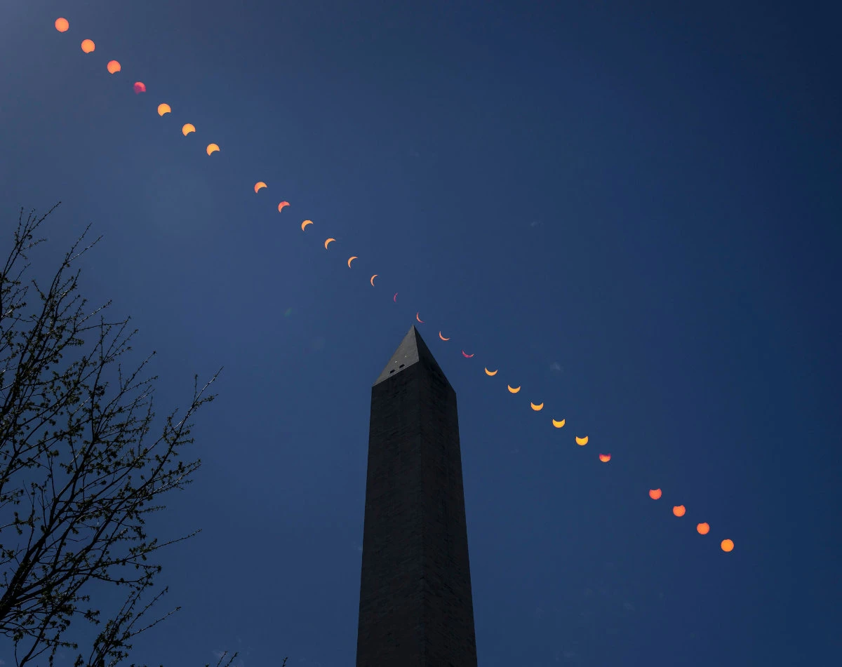 This composite image of multiple exposures shows the progression of a partial solar eclipse over the Washington Monument in the US capital on April 8, 2024. (NASA via AP)