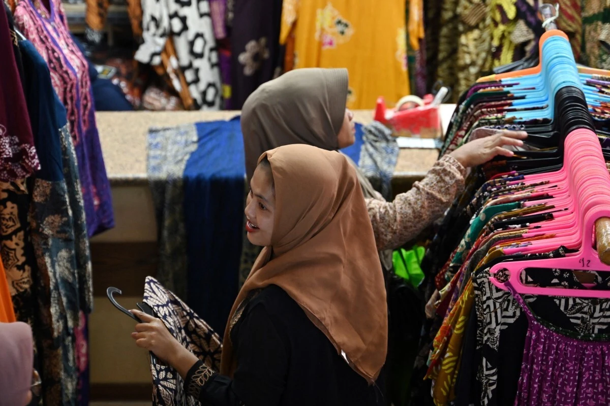 People shop for Eid Al-Fitr celebration at the Tanah Abang textile market in Jakarta on April 3, 2024. (AFP