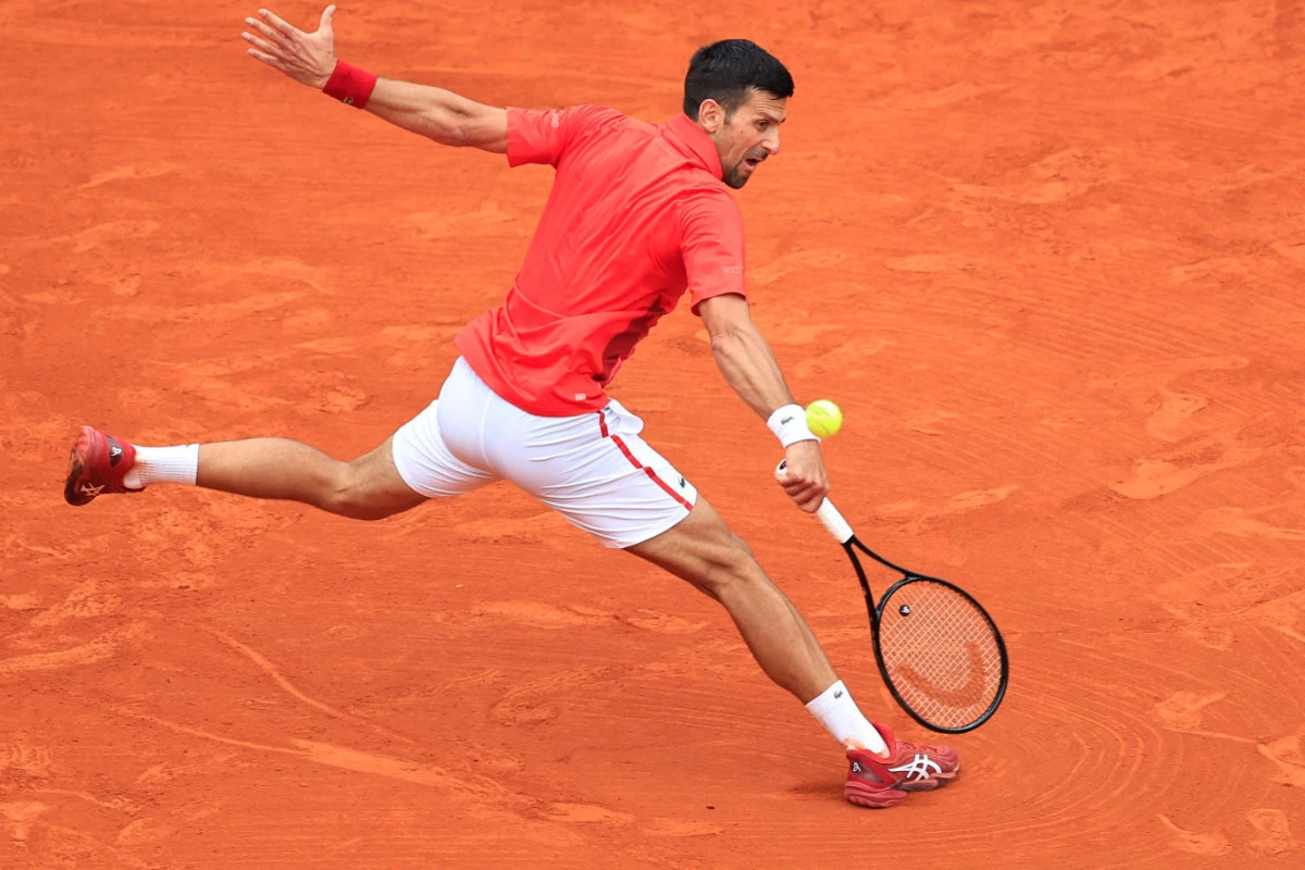 Serbia's Novak Djokovic plays a backhand return to Russia's Roman Safiullin during their Monte Carlo ATP Masters Series Tournament round of 32 tennis match on the Rainier III court at the Monte Carlo Country Club on April 9, 2024. (AFP)