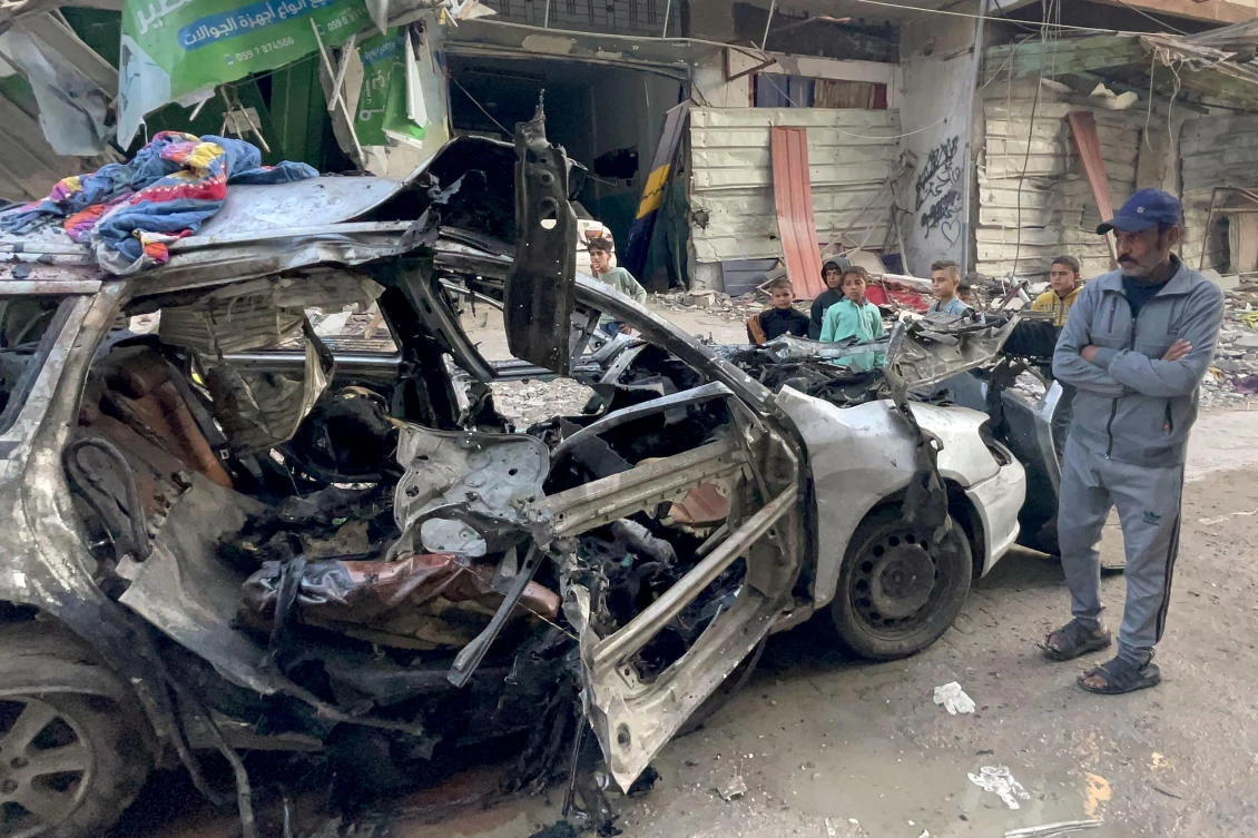 Onlookers check the car in which three sons of Hamas leader Ismail Haniyeh were reportedly killed in an Israeli air strike in Al-Shati camp, west of Gaza on Apr. 10, 2024. (AFP)