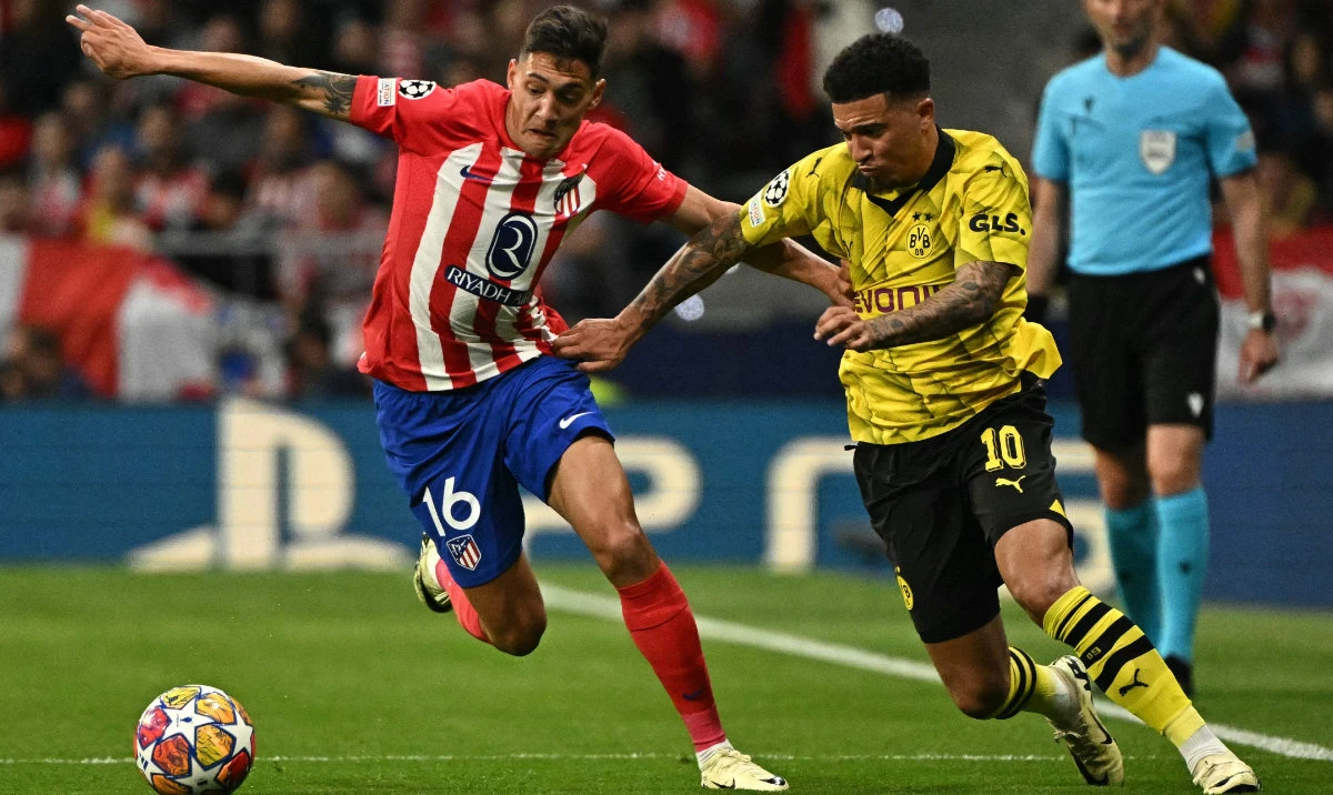 Atletico Madrid's Argentine defender Nahuel Molina (L) fights for the ball with Dortmund's English midfielder Jadon Sancho during the UEFA Champions League quarter final first leg football match between Club Atletico de Madrid and Borussia Dortmund in Madrid on April 10, 2024. (AFP)