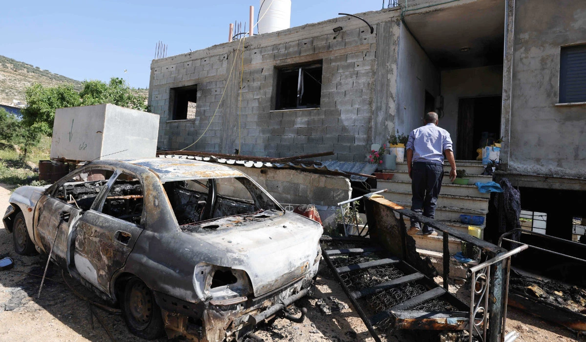 A Palestinian inspects the damage to a home in the village of Al-Mughayir near Ramallah in the West Bank on Saturday after an attack by Israeli settlers. (AFP)