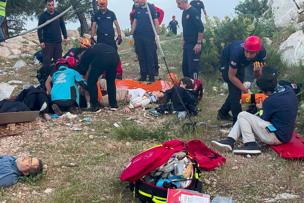 Rescue and emergency team members work with passengers of a cable car transportation system outside Antalya, southern Turkiye, on April 12, 2024. Scores of other people left stranded late into the night after the entire cable car system came to a standstill were rescued on Saturday. (Dia Images via AP)