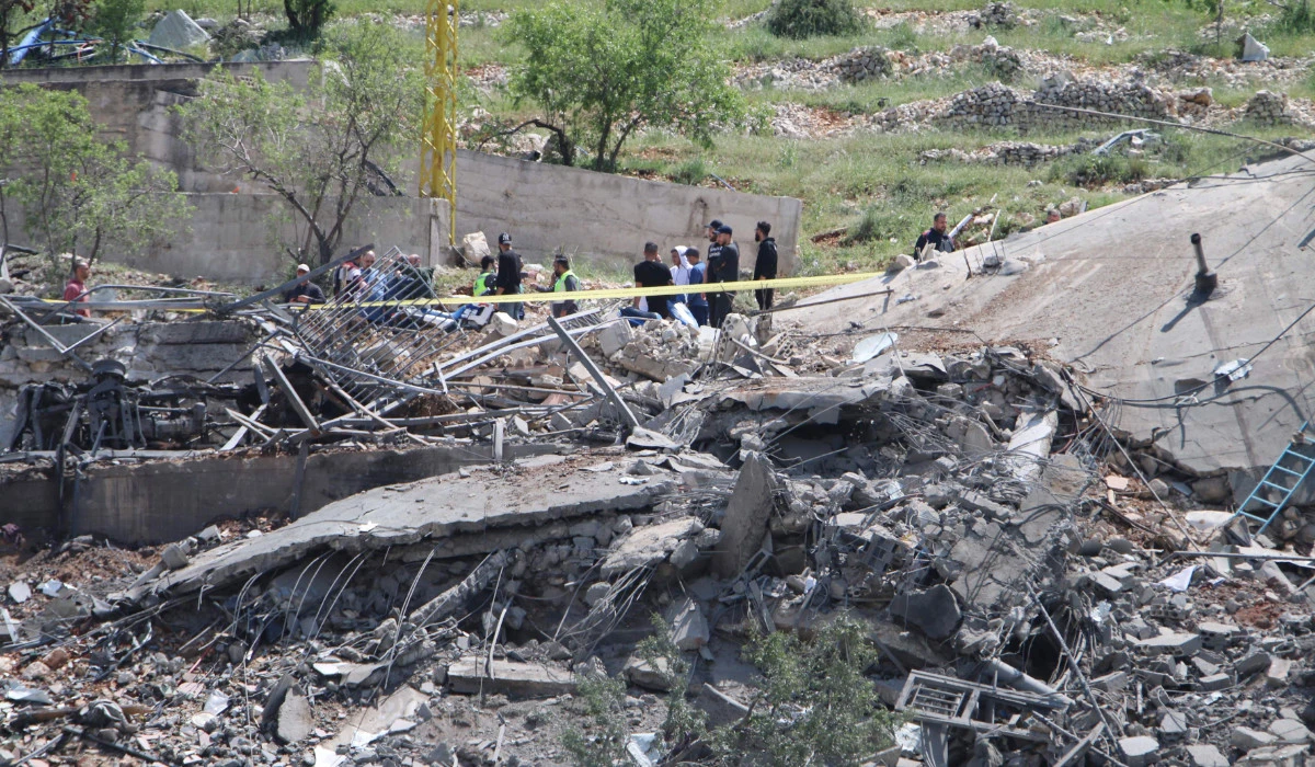 People gather around a destroyed building targeted by Israeli air strikes on the village of Nabi Sheet in the Baablbek district in Lebanon's eastern Bekaa Valley on April 14, 2024, as tensions in the region soared after Iran directly attacked Israel. (AFP)