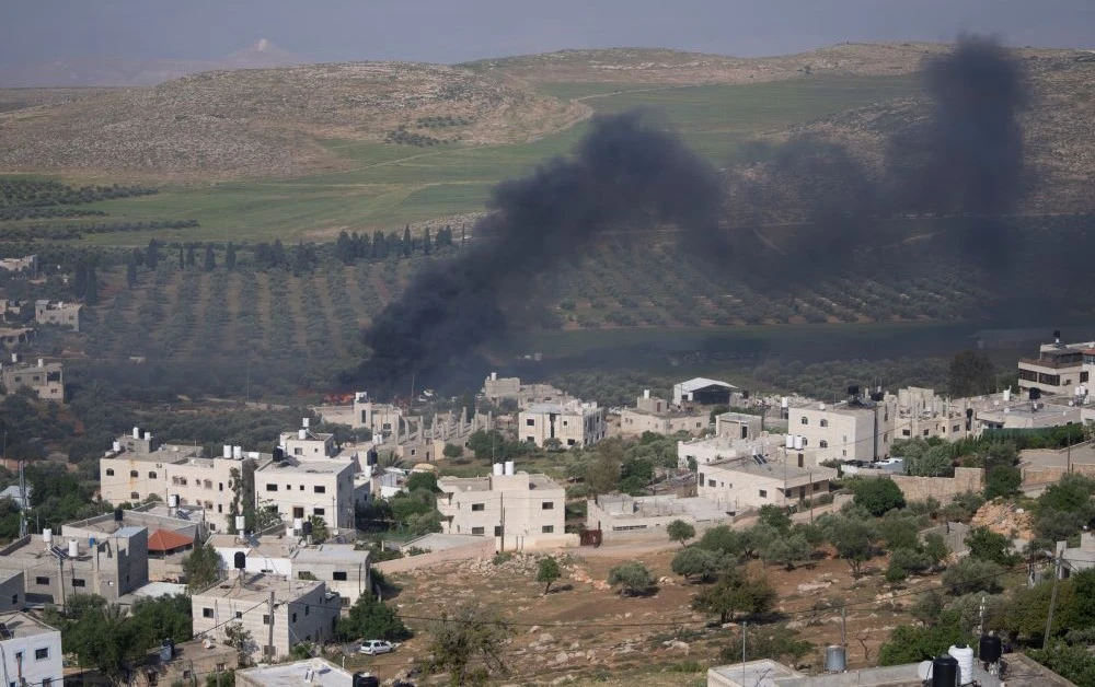Smoke fills the sky after Israeli settlers set fire to the properties of Palestinian villagers in the West Bank village of Al-Mughayyir, Saturday, April 13, 2024. (AP Photo)