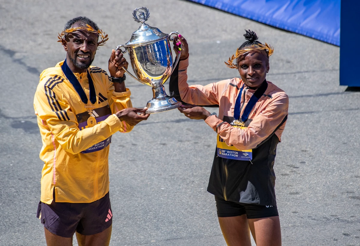 Sisay Lemma of Ethiopia and Hellen Obiri of Kenya hold the race trophy together after both taking first place in the men’s and women’s professional fields during the 128th Boston Marathon in Boston, Massachusetts, on April 15, 2024. (AFP)