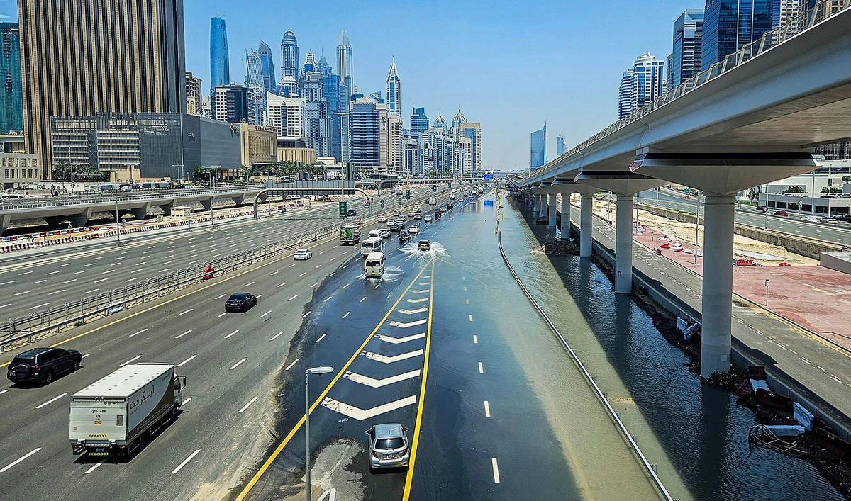 Vehicles move along the partially flooded Sheikh Zayed road (E11 highway) near the Dubai Marina Mall in Dubai on April 18, 2024, in the aftermath of heavy rains. (AFP)