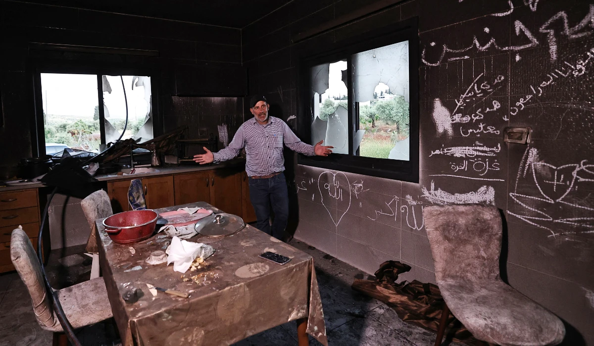 A Palestinian man stands inside his kitchen in the aftermath of an attack by Israeli settlers in occupied West Bank village of Al-Mughayyir near Ramallah. (AFP)