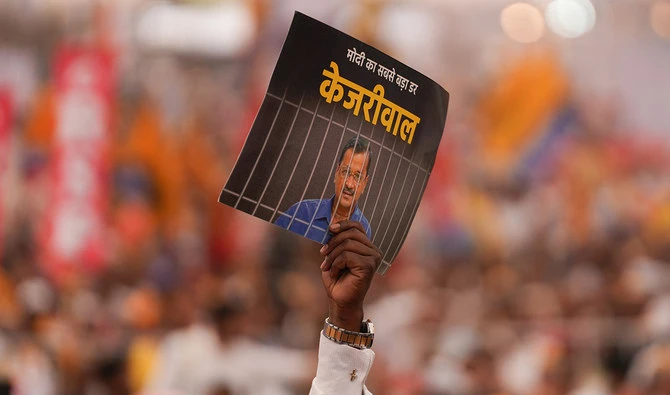 Supporters of India's opposition coalition comprising of various political parties named ‘INDIA’ or Indian National Developmental Inclusive Alliance, shouts slogans and displays a placard with a message on AAP chief and Delhi Chief Minister Arvind Kejriwal, during a rally held in New Delhi on March 31, 2024. (AFP/File)
