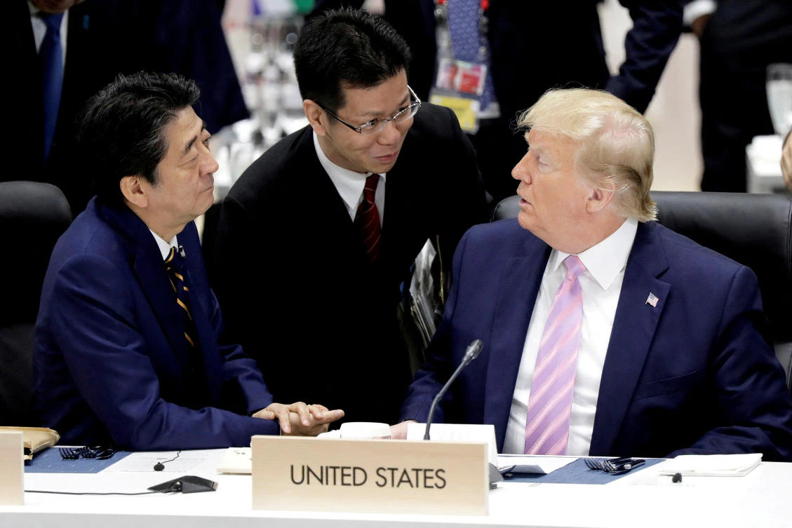Sunao Takao (C) helps with translation as Japan’s then-Prime Minister Shinzo Abe and US President Donald Trump talk prior to a working lunch at the Group of 20 summit in Osaka in June 2019. (Reuters/File)