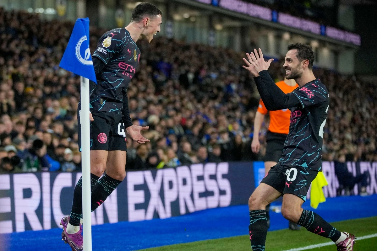 Manchester City's Phil Foden, left, celebrates with teammate Bernardo Silva after scoring his side's second goal during the English Premier League soccer match between Brighton and Manchester City at the Falmer Stadium in Brighton, England, Thursday. (AP)