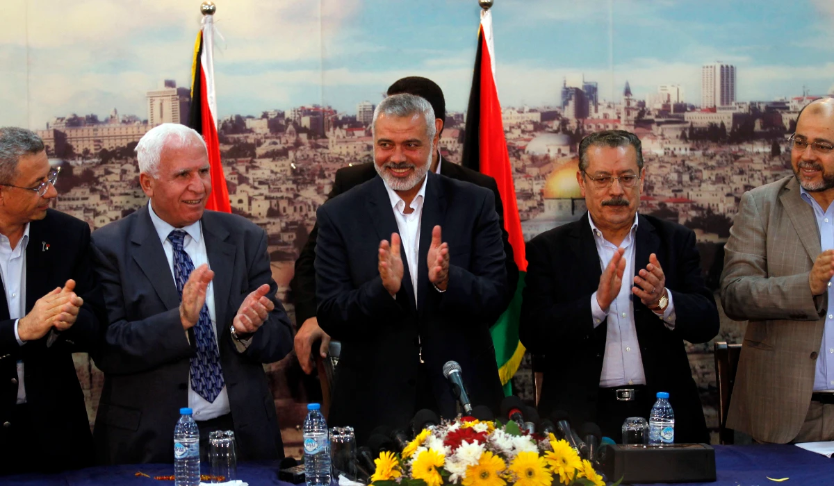 (From L to R) Palestinian legislator Mustafa Barghouti, Palestinian Fatah delegation chief Azzam al-Ahmed, Hamas prime minister in the Gaza Strip Ismail Haniya, secretary-general of the Palestinian Arab Front (PAF) Jameel Shehadeh and Hamas deputy leader Musa Abu Marzuk clap as they celebrate in Gaza City on April 23, 2014 after West Bank and Gaza Strip leaders agreed to form a unity government within five weeks as peace talks with Israel face collapse. (AFP file photo)
