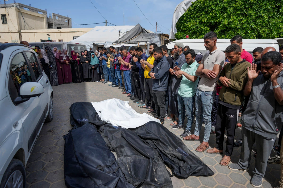 Mourners pray over the bodies of Palestinians who were killed in an Israeli airstrike in Nuseirat, at the Al Aqsa hospital in Deir al Balah, Gaza Strip, on April 27, 2024. (AP)