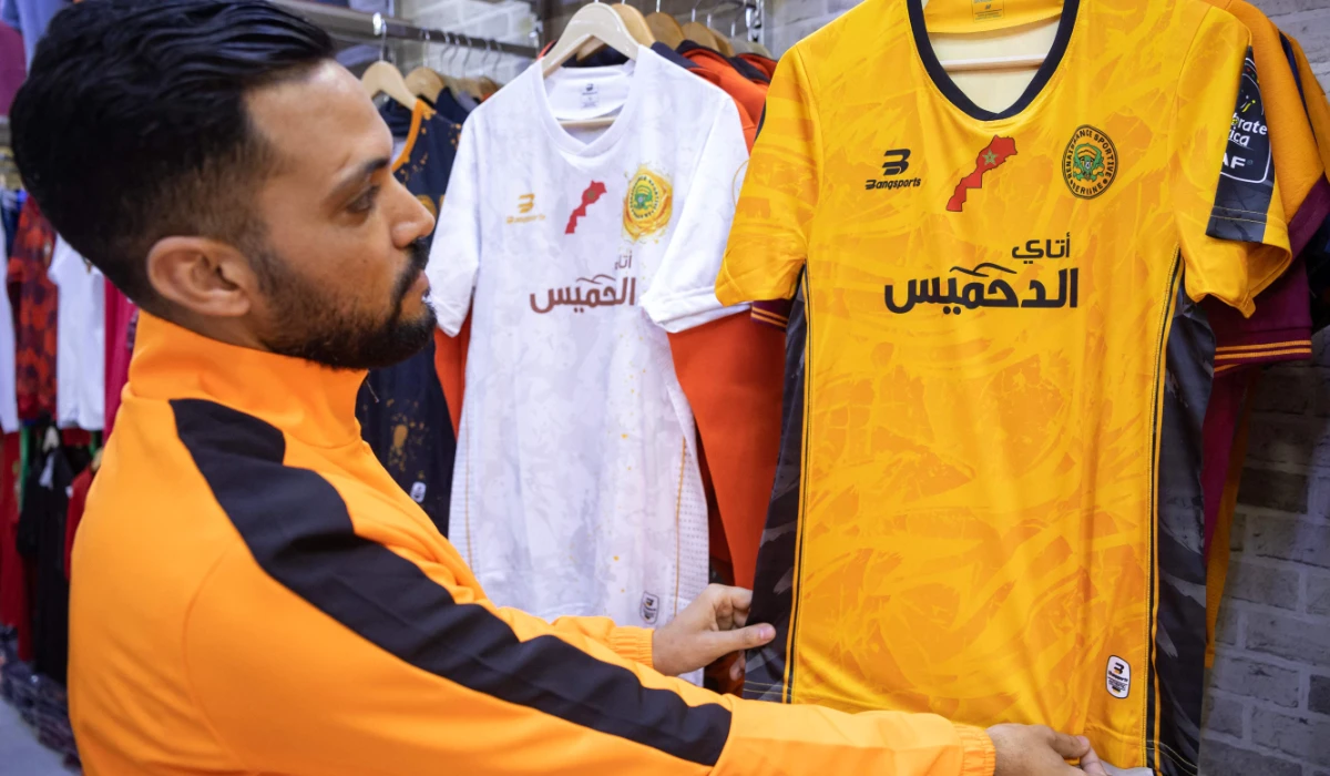 A supporter of Morocco's RS Berkane football team checks the team's jersey at a shop in the city of Berkane on April 27, 2024, on the eve of the second leg of the CAF Confederation Cup semi-final. (AFP)