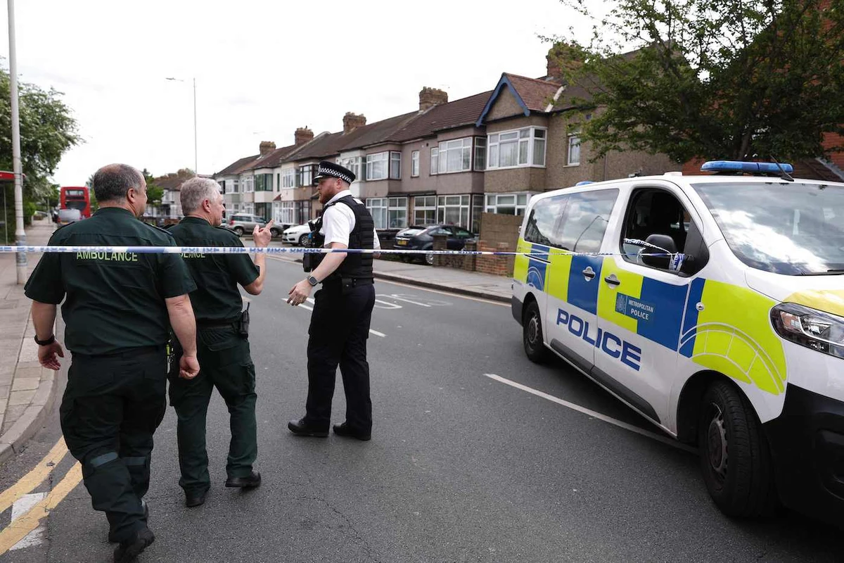A police officer speaks to ambulance staff at a crime scene in Hainault, east of London on April 30, 2024 where a 36-year-old man wielding a sword was arrested. (AFP)