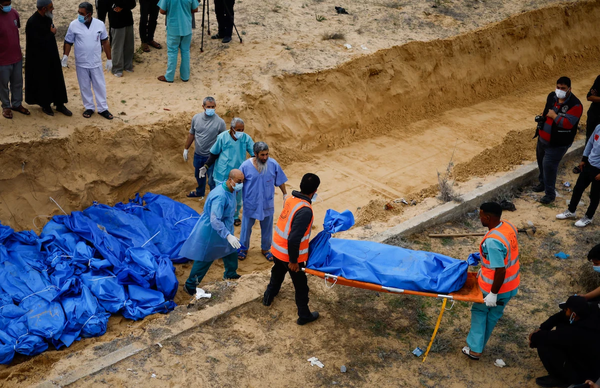 The bodies of Palestinians killed in Israeli strikes are buried in a mass grave, after they were transported from Al-Shifa hospital in Gaza City for burial, in Khan Younis, the southern Gaza Strip. (File/Reuters)
