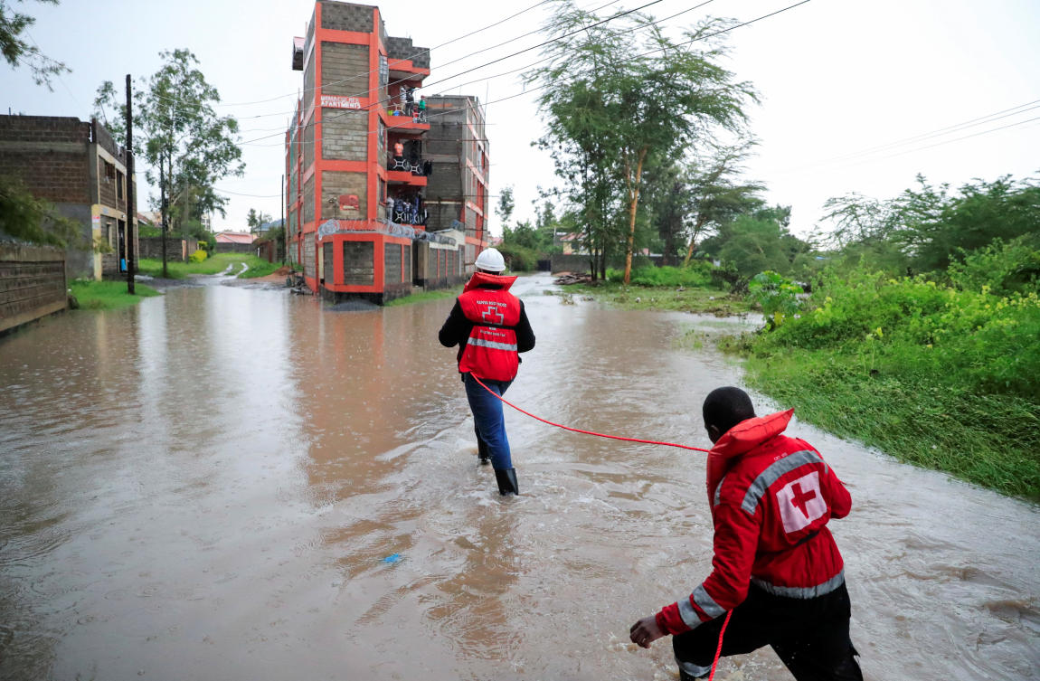 Kenya Red Cross members hold on to a safety rope as they wade through flood waters to rescue residents trapped in their homes marooned after a seasonal river burst its banks following heavy rainfall in Kitengela municipality of Kajiado County, near Nairobi on May 1, 2024. (Reuters)