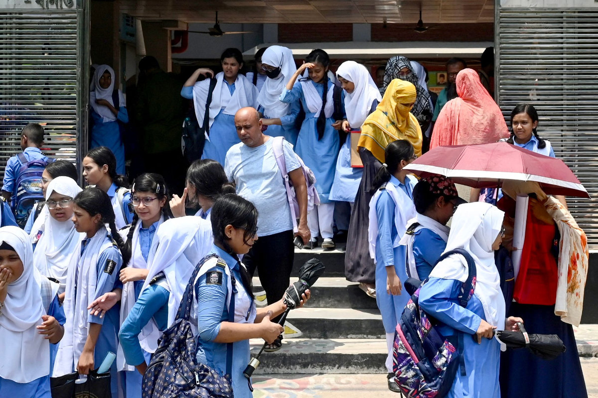 Students leaving their school compound carry umbrellas on a hot summer day in Dhaka, Bangladesh, on April 28, 2024, amid the ongoing heatwave.(AFP)