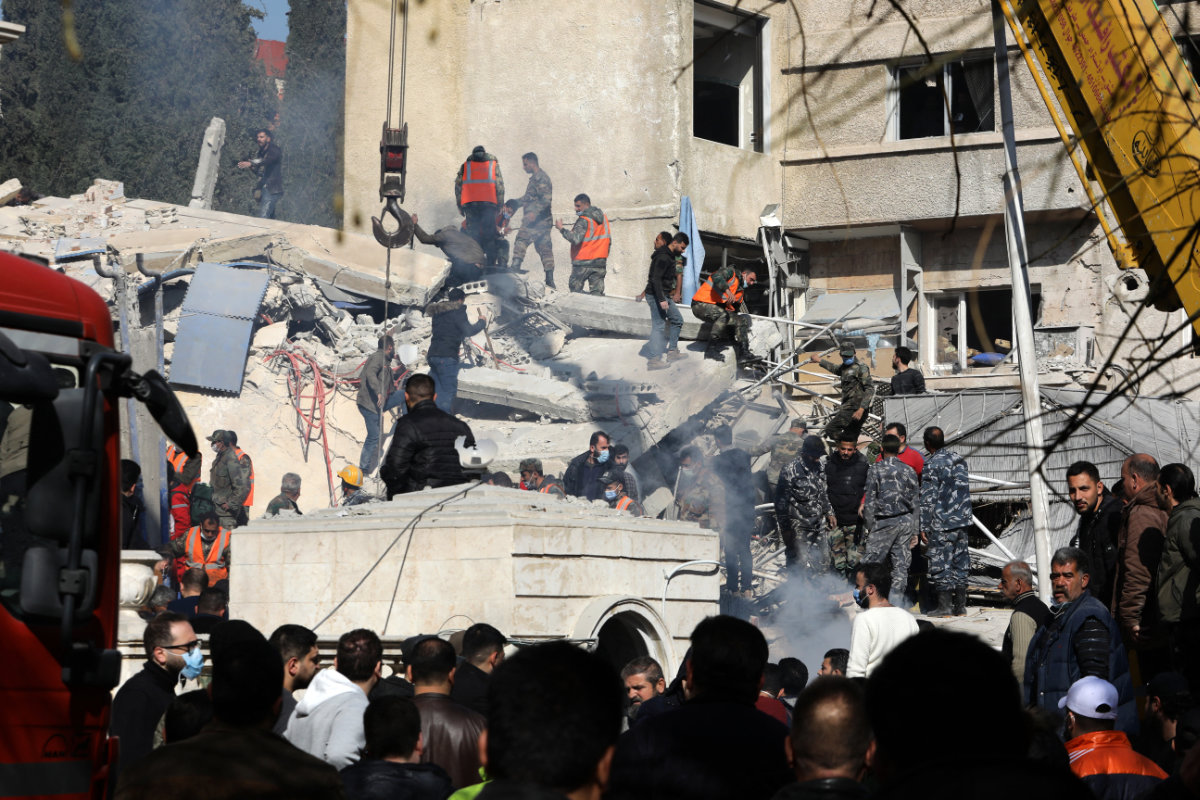 In this picture taken on January 20, 2024, Syrian security and emergency personnel search the rubble of a building destroyed in an Israeli strike in Damascus, killing an Iranian Revolutionary Guards' intelligence official and three other Guards members. (AFP)