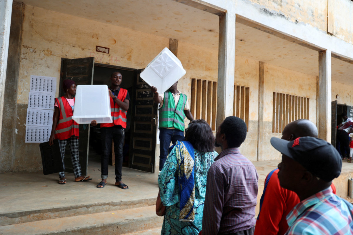 Electoral workers show empty ballot boxes at a polling station in Lome, Togo, on April 29, 2024, before it opens for the parliamentary and regional elections. (REUTERS)