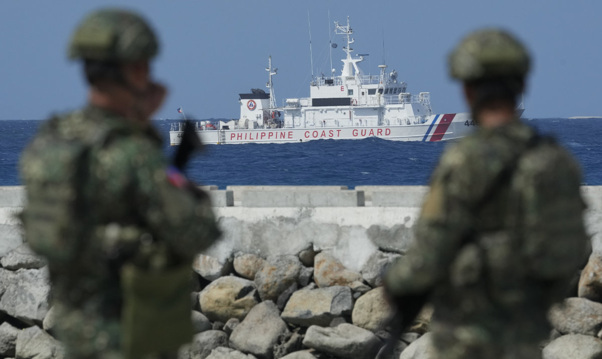 Philippine troops watches a Philippine coast guard ship as they secure an area at the Philippine-occupied Thitu island, locally called Pag-asa island, on Dec. 1, 2023 at the disputed South China Sea. For the first time, China has publicized what it claims is an unwritten 2016 agreement with the Philippines over access to South China Sea islands. (AP/File)