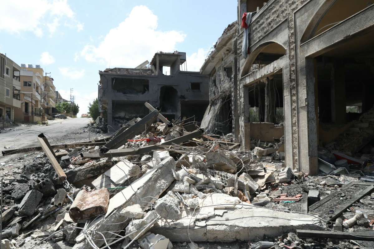 Debris are scattered around buildings damaged by an Israeli strike in the southern Lebanese border village of Mays al-Jabal on May 5, 2024 (AFP)