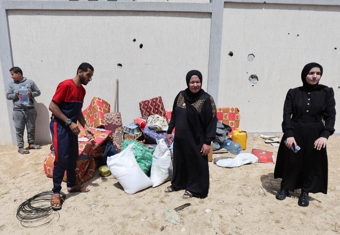 Displaced Palestinians stand next to belongings, in the Al-Mawasi area, in Khan Younis in the southern Gaza Strip, May 6, 2024. (Reuters)