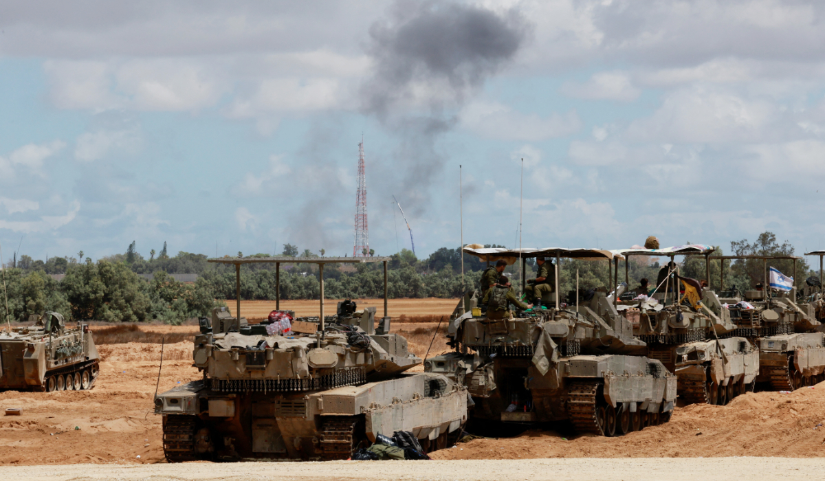 Israeli soldiers sit on tanks as smoke billows in the distance, amid the ongoing conflict between Israel and the Palestinian Islamist group Hamas, near the Israel-Gaza Border, in Israel, May 6, 2024. (REUTERS)