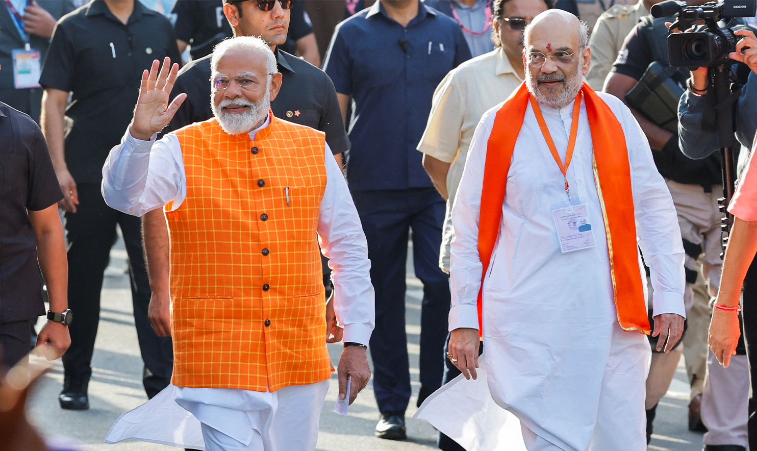 India's Prime Minister Narendra Modi walks alongside Amit Shah, Indian Home Minister and leader of India's ruling Bharatiya Janata Party (BJP) on the day he casts his vote, outside a polling station during the third phase of the general election, in Ahmedabad, India, on May 7, 2024. (REUTERS)