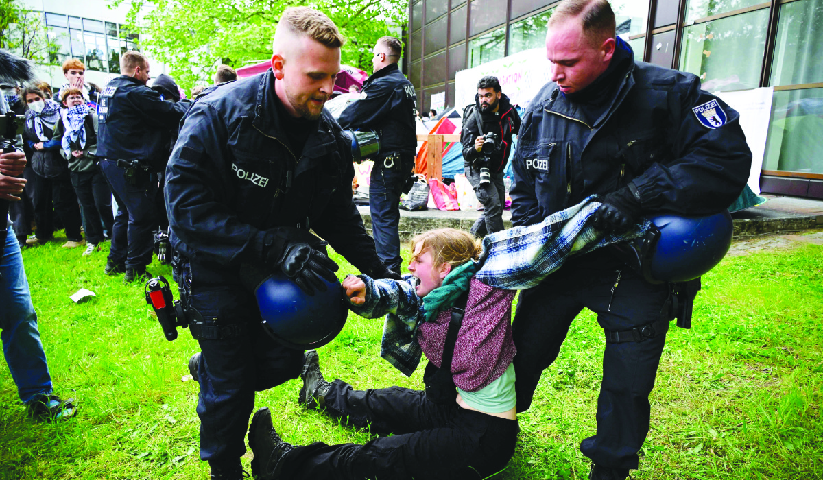 A pro-Palestinian activist is carried away from the campus of the Free University of Berlin as police try to break up a demonstration against Israel’s war in the Gaza Strip. (AFP)