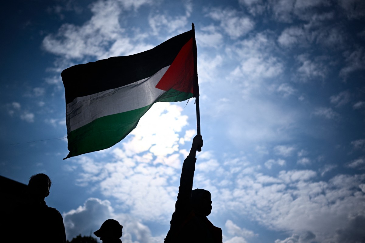 A protester holds a Palestinian flag during a rally called by several French organisations in support of Palestinian people at Place de la Republique in Paris on May 7, 2024 (AFP)