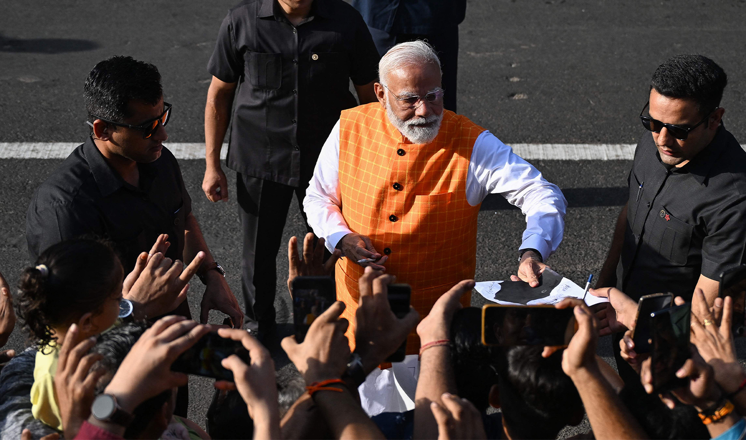 India's Prime Minister Narendra Modi (C), leader of the ruling Bharatiya Janata Party (BJP) interacts with his supporters as he leaves after casting his ballot at a polling booth at Ranip, Ahmedabad on May 7, 2024. (AP)
