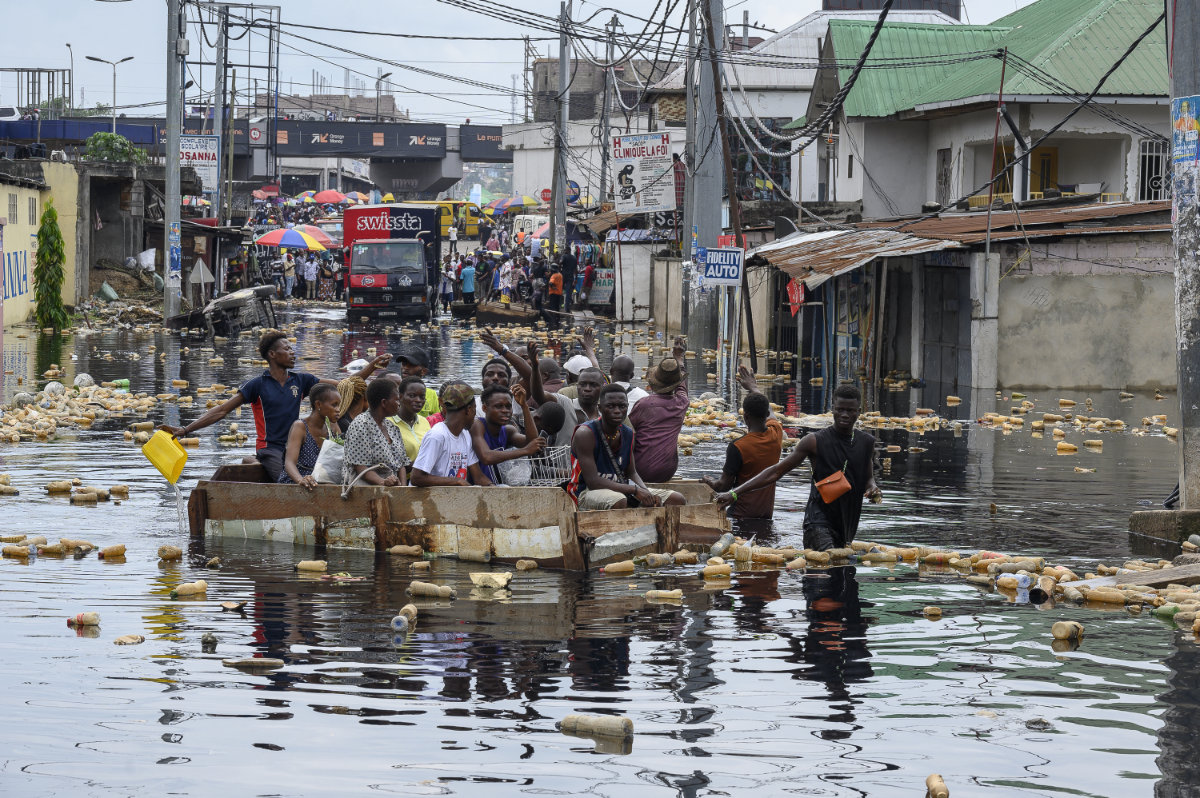 People cross the floodwater of the Carrigrès bridge in a pirogue in the Pompage district in Kinshasa on January 9, 2024 following heavy rains and the flood of the Congo River. Unusually heavier rainfall prompted by climate change has forced rivers and lakes in the central African country to overflow, swallowing towns, villages and roads on the shores. (AFP)