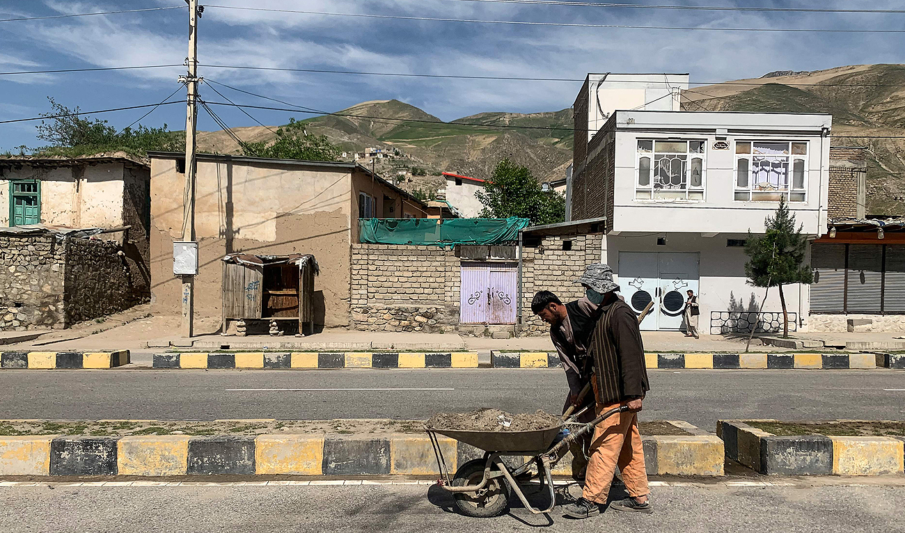 Afghan Municipal workers clean the site of a sticky bomb that detonated next to a security convoy in Fayzabad of Badakhshan province on May 8, 2024. (AFP)