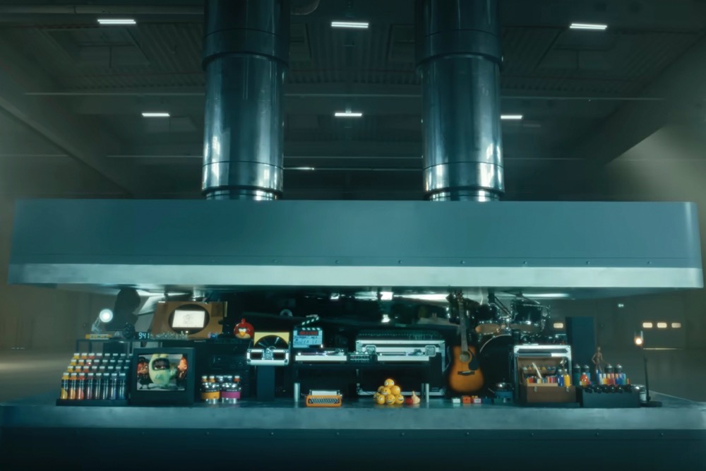 The ad shows a hydraulic press crushes an array of creative instruments. (Apple via AP)