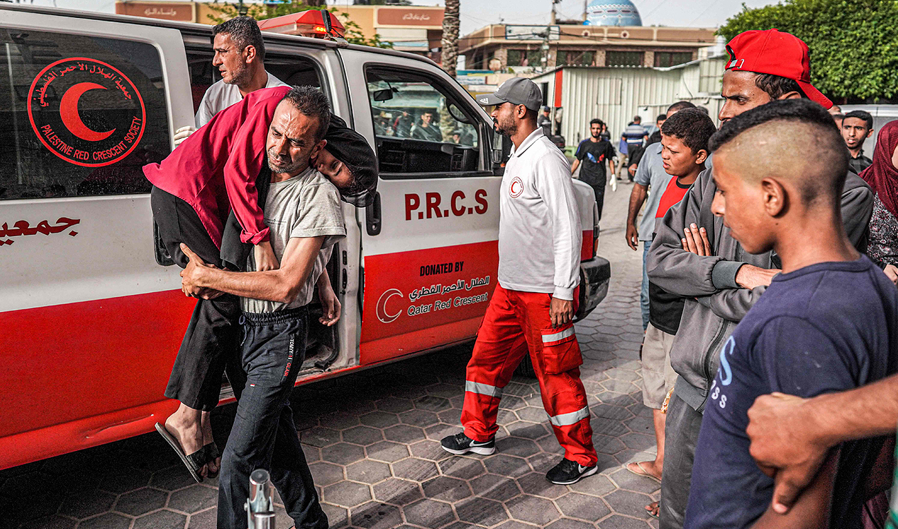 A man carries an injured child into the Aqsa Martyrs Hospital in Deir el-Balah in the central Gaza Strip on May 11, 2024 amid the ongoing conflict in the Palestinian territory between Israel and Hamas. (AFP)